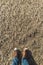 Brown leather shoes on frozen beach sand. The concept of the cold winter weather season. Top view, copy space