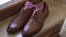 Brown leather shoes and the groom`s bow tie stand on the windowsill while getting ready