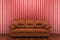Brown leather sofa in front of red wall