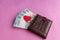 Brown leather wallet with red heart. Belarusian hundred-ruble bills stick out of the wallet.