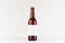 Brown longneck beer bottle 330ml with blank white label on white wooden board, mock up.