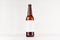 Brown longneck beer bottle 500ml with blank white label on white wooden board, mock up.