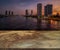 Brown marble table or floor with a background of the riverside city at night, little shiny surface, perspective view, empty space