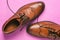 Brown men`s shoes close-up. Classic shoes with untied laces on a pink background. Shoes for weddings, everyday walking