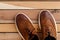 Brown mens shoes on wooden background. top view