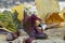 Brown miniature boot filled with daisies, shoe lace bow, on yellowed autumn leaves and chestnuts background