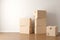 Brown moving storage cardboard boxes stacked in empty room in apartment or house with wooden floor with copy space