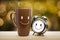 Brown mug and alarm clock with a happy smile