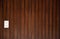Brown natural textured wood panel wall boarding background with white Asian electricity socket. Interior decoration architectural