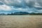 Brown ocean water with dramatic sky on the background