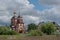 Brown Orthodox Church of Presentation of the Lord with bell tower and spire, round top and gilded Orthodox crosses.