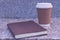 Brown paper cup of coffee with notebook or diary in the park with copy space. Time to get rest and relax after hard working. Photo