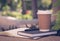 Brown paper cup of coffee with notebook or diary in the park with copy space. Time to get rest and relax after hard working. Photo