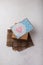 Brown paper present box, blue postcard with pink heart on white background. Valentines day, birthday surprise