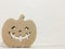 A brown paper in smile ghost pumpkin shape on white cement copy space wall background. Halloween concept