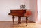 Brown piano in a pink room