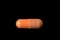 Brown pill isolated on black