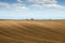 Brown plowed field and tractor