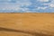 Brown plowed non-seeded field on a background of blue summer sky. sunny sky over an empty meadow. serenity, bliss. desktop