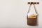 Brown postman bag with newspapers and mails hanging on light wall, space for text