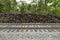 Brown railroad ties piled up next to active train tracks