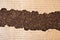 Brown recycled paper ripped pieces on dark brown cork board background , space for text