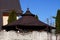 Brown roof gazebo behind a gray concrete fence