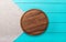 Brown round cutting board for holiday dishes on gray linen napkin. Blue wooden background in the restaurant.copy space