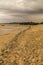 Brown sand beach on a grey rainy cloudscape