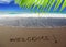 Brown sand beach with written word Welcome