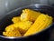 Brown Saucepan with boiling yellow tasty  corn and steam above it
