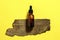 Brown serum or oil glass mock up bottle with pipette on yellow background. Bark of tree on backdrop. Concept of natural organic co