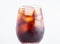 Brown soda, cold tea or coffee with ice cubes. Fresh cold sweet drink with ice cubes on white background with copy space. Fresh