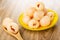 Brown spoon with lychee, saucer with canned lychees on wooden table