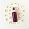 Brown spray bottle and round chamomiles frame on ivory background. Cometic bottle for branding and label. Top view, Flatlay