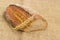 Brown sprouted bread and wheat ear closeup on sackcloth