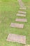 Brown stone path and fresh green gress or Brown stone slab on the fresh green lawn