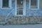 Brown stone threshold with steps and iron handrails on the sidewalk against the wall of the house