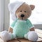 Brown stuffed animal teddy bear in mint-colored clothes. Closeup