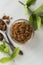 Brown sugar isolated in glass bowl, over styled marble background. Mint leaves. Top view, copy space