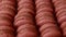 Brown sweet french macaron cakes with chocolate topping in row on the cafe display. Sets of desserts from almond dough