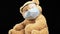 Brown teddy bear sits in protective plastic glasses, a medical disposable mask, concept of pediatrics