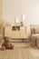 Brown teddy bear sitting on the floor of beige bedroom interior with wooden commode