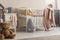 Brown teddy bear on the wooden floor of scandinavian baby bedroom interior with white nightstand and cribs