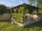 Brown tiber wooden gazebo or pergola with climbing plants and fl