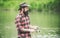 Brown trout being caught in fishing net. Fly fisherman using fly fishing rod in beautiful river. Angler. Fly rod and