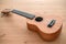 Brown ukulele on wooden background with shallow depht of field