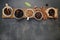 Brown unroasted and dark roasted coffee beans in coffee cup with scoops setup on dark stone background