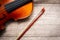 Brown violin with fiddle stick on wooden background. Art and mus