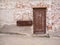 Brown weathered door in weathered brick wall